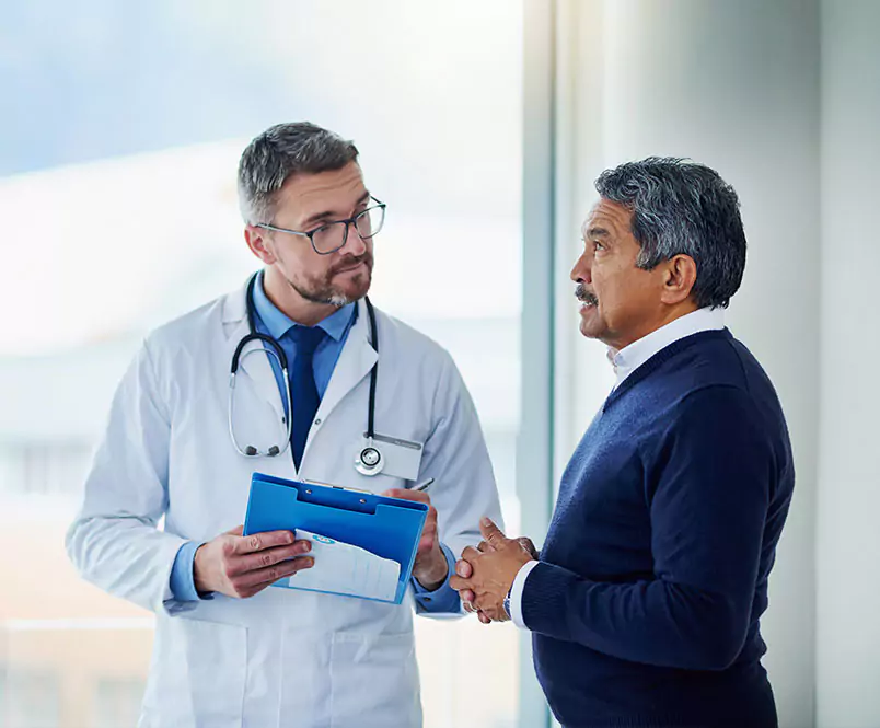Standing in front of a window in a medical center, a man talks while his doctor takes notes. Social Security runs both Social Security Disability Insurance (SSDI) and Supplemental Security Income (SSI).