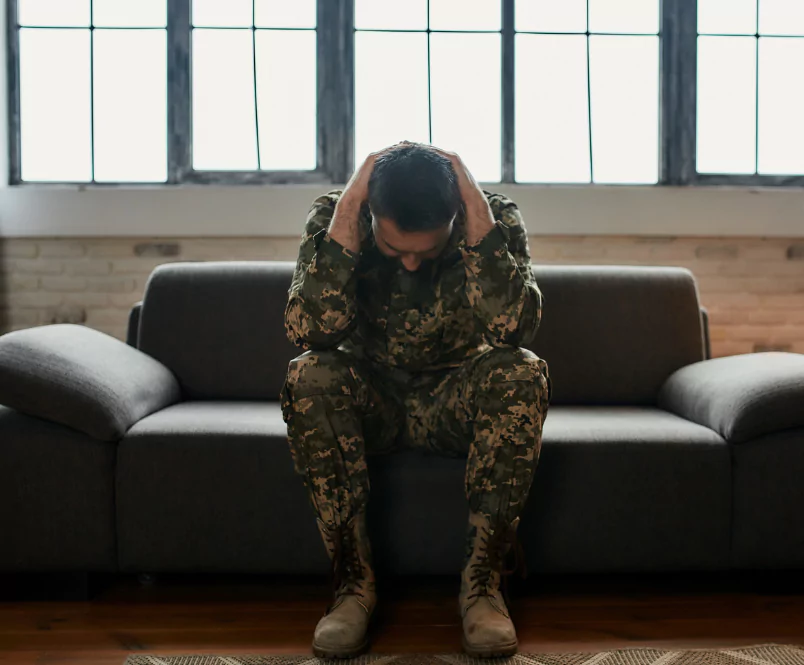 A solder in fatigues sits on a couch, a row of windows behind him, looks down, and puts his hands behind his head. Silver & Archibald lawyers in Georgia help with VA Malpractice cases.